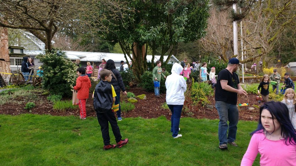 families hunting Easter eggs in grass at Ovenell’s Heritage Inn