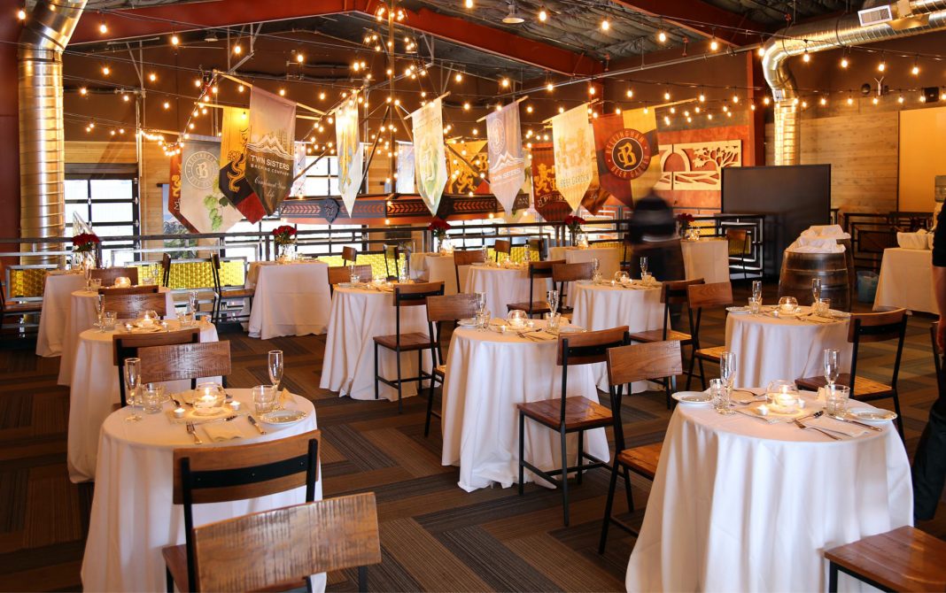 mezzanine at Twin Sisters Brewing decorated event space with white linen tables, banners and lights