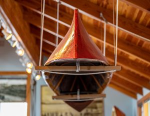 Betty Lowman's red canoe suspended from the rafters for the Bijaboji In the rafters in the rafters of the Anacortes Museum and Maritime Heritage Center.