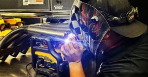 Troy Sato repairing a header pipe on Paul Lee's Funny Car