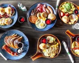 six skillets full of food on a wood table