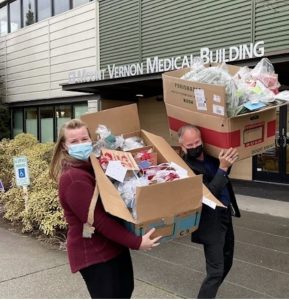 One Community One Family volunteers with boxes of wreath decorations for their fundraiser