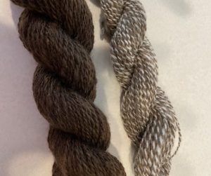 two bundles of yarn, one brown one grey, made from shetland sheep wool