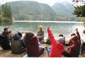 kids sitting on the beach of Diablo Lake with a teacher at North Cascades Mountain School