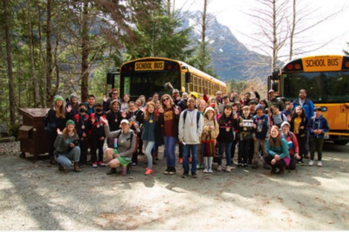 a huge group of students outside a bus at North Cascade Mountain School