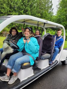 people in a golf cart at Camp Korey