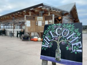 welcome sign at Finnriver Farm & Cidery with a building in the background