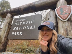 Writer Jess Caldwell by Olympic National Park sign