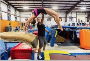 child doing a back spring with instructor by her side at Ground Zero Gym in Skagit County