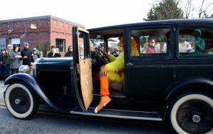 man dressed as a chicken driving a vintage care