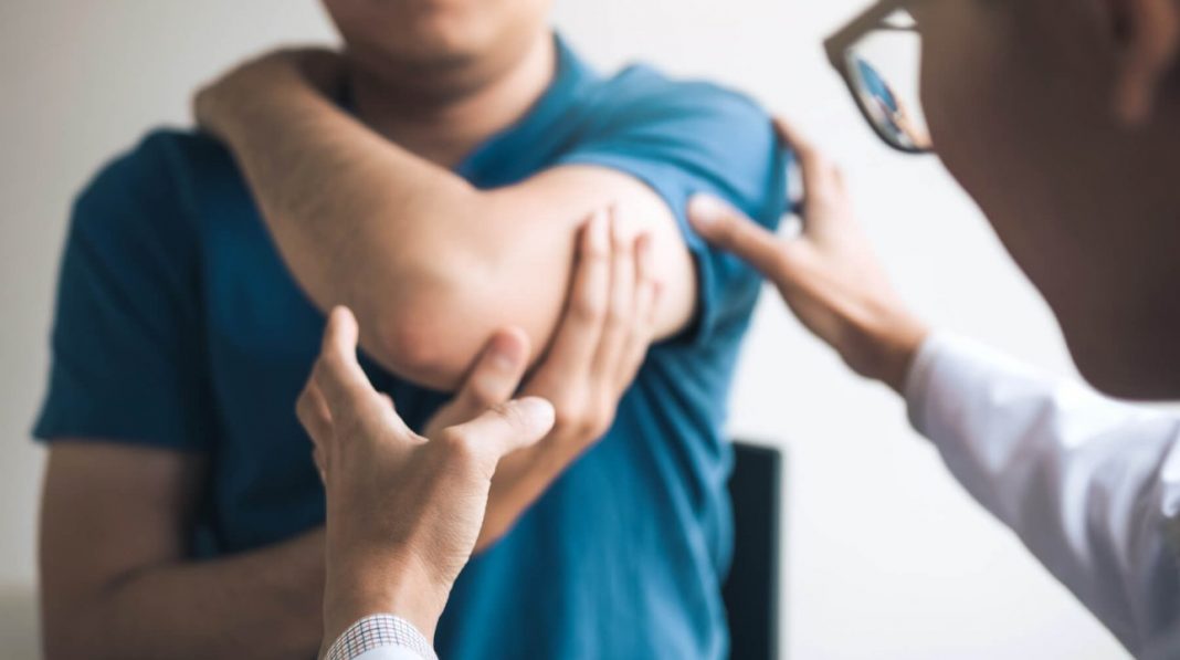 doctor examining someone's elbow