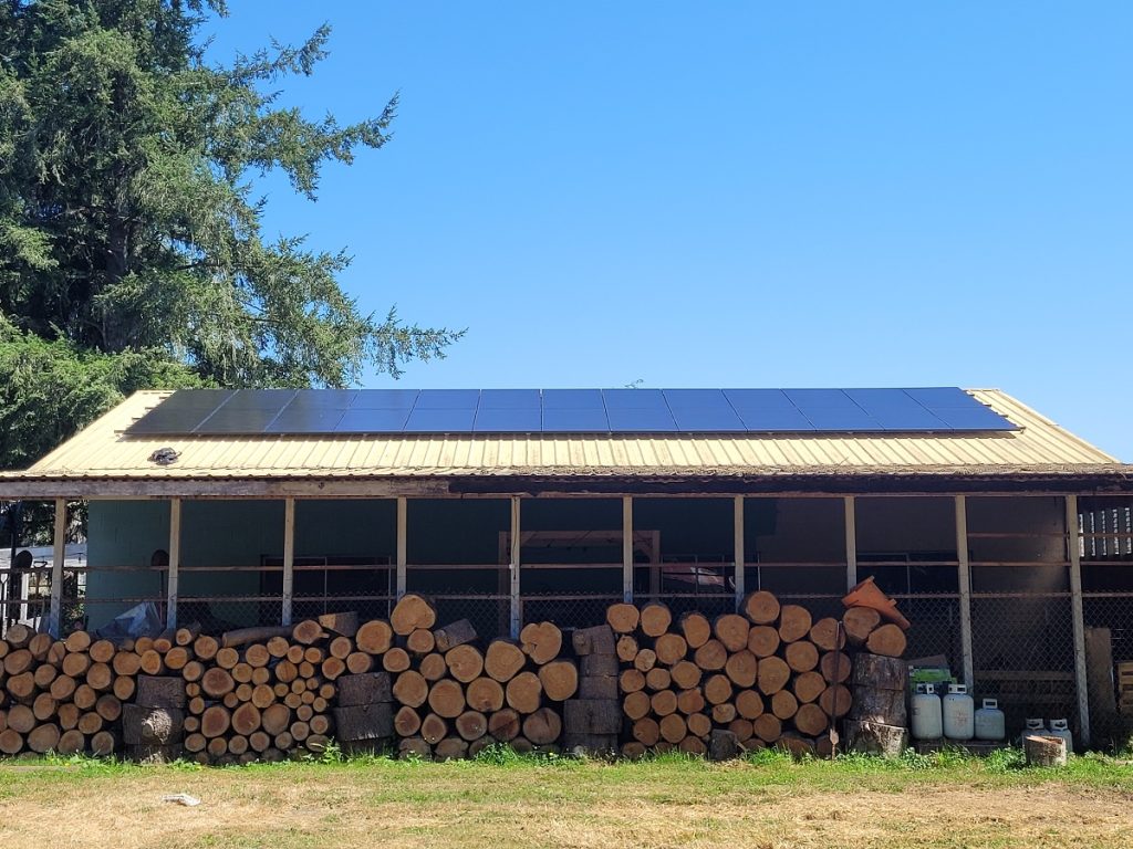 solar panels on a long shed full of wood