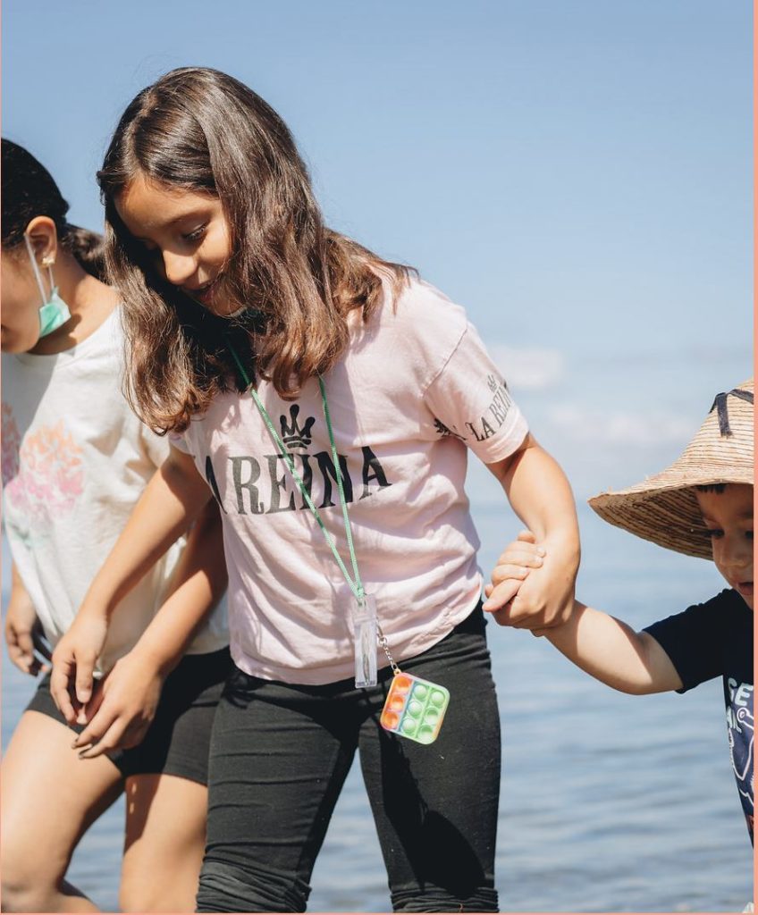 girls holding hands and walking on the beach