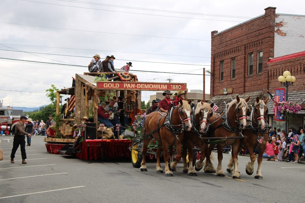 large parade float pulled by four draft horses