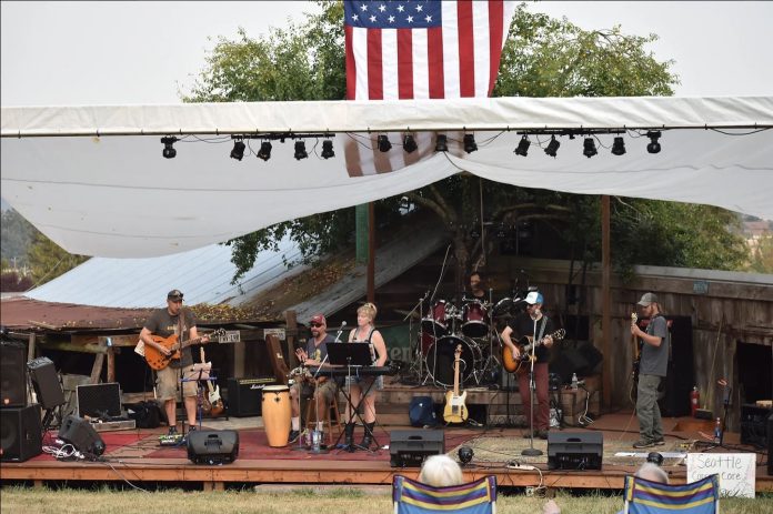 a band performing on an outdoor, covered stage