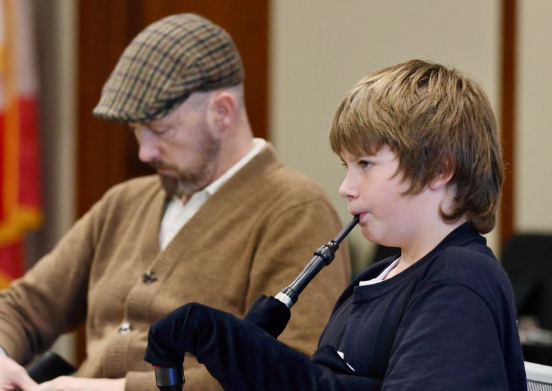 a man and a young boy playing celtic instruments
