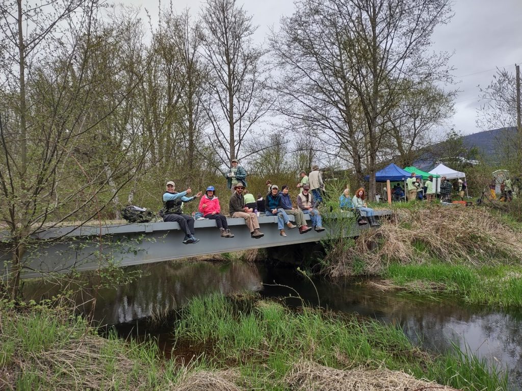 volunteer work party sitting on a bridge in the Skagit Land Trust's Utopia Conservation Area