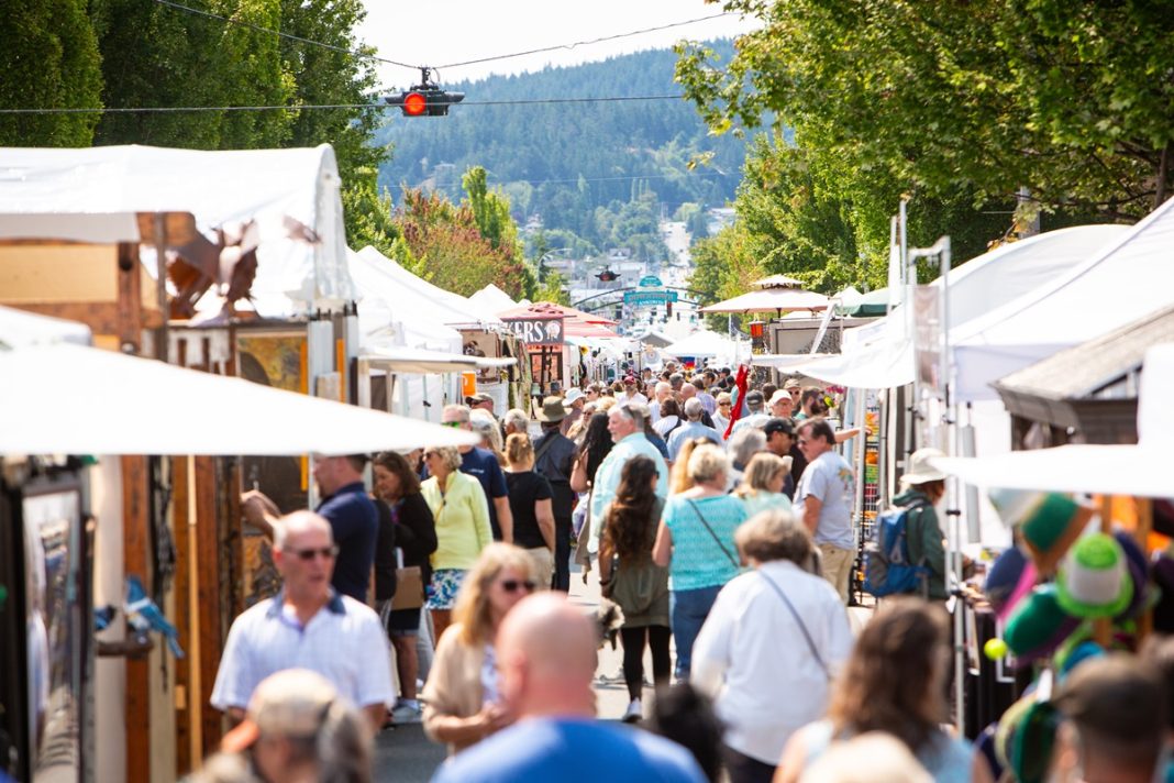 large group of people walking through pop up tents at the Anacortes Arts Festival