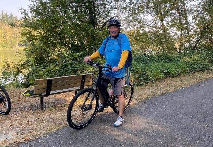 man straddling his bike on the paved Chehalis Western Trail