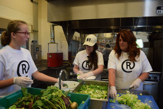 3 women prepare food in a kitchen