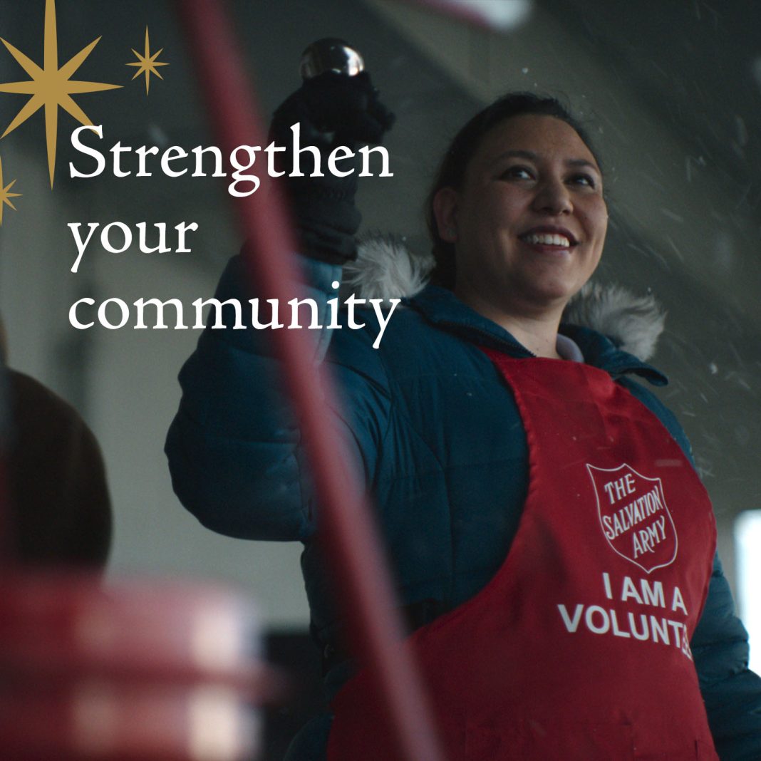 a woman rings a bell while wearing a Salvation Army Apron. The text 'Strengthen our Community' is superimposed over the photo