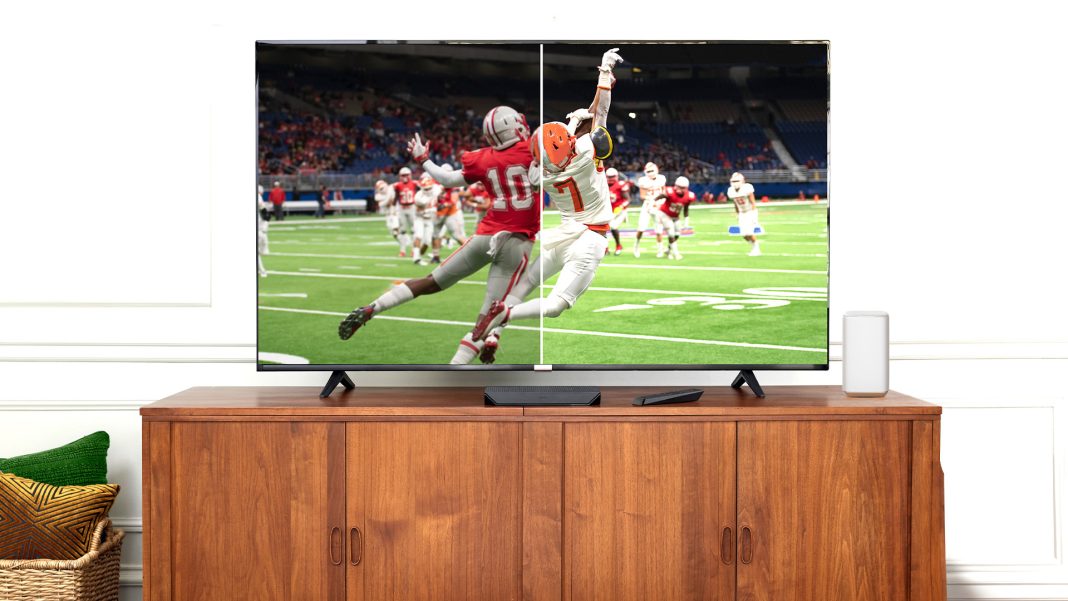 a large screen TV with a football game on it sitting on a wood console in front of a white background