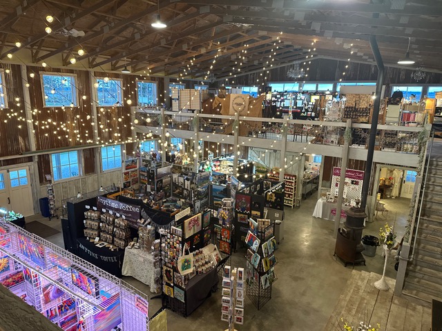 view from above of the PNW Artist Marketplace inside the Vinery with lights strung and lines of vendor booths