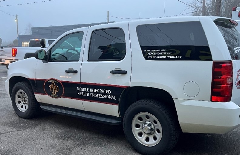 a white SUV with a black decal that says Mobile Integrated health professional across the two doors.